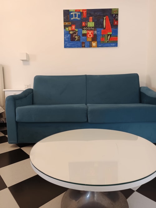 Divano blu con tavolo tondo bianco nella moderna camera d'albergo di Palazzo di Donna, Sant'Egidio del Monte Albino