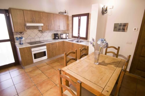 Küche und Essbereich in der Villa Rodrigo bei Sara & Gino Fuerteventura, Corralejo mit Holzschränken und Tisch
