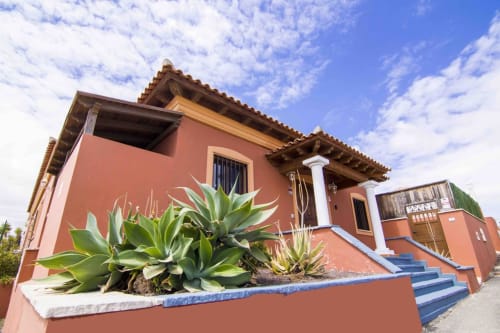 Villa Rodrigo bei Sara & Gino Fuerteventura in Corralejo mit Lehmziegelmauern, blauen Akzenten und sukkulentenreicher Bepflanzung