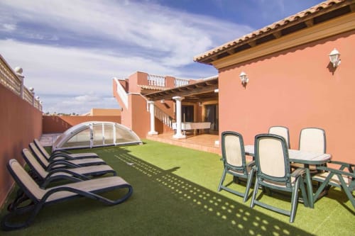 Sonnige Terrasse der Villa Sara & Gino auf Fuerteventura mit Liegestühlen, Sitzplatz und Poolbereich in Corralejo