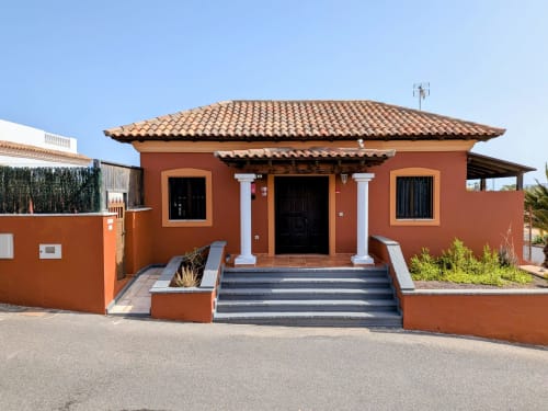 Villa Sara & Gino auf Fuerteventura mit Terrakotta-Fassade und weißen Säulen in Corralejo, Spanien