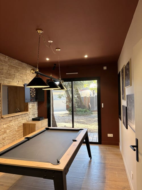 Salle de jeux moderne à la villa Les Villas de Jade avec billard, luminaires suspendus noirs et vue sur le jardin
