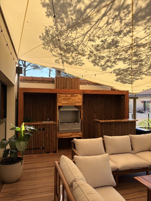 Patio de la Villa Acacia aux Villes de Jade avec terrasse en bois, mobilier beige, voile d'ombrage et structure en bois à Saint-Brèvin les