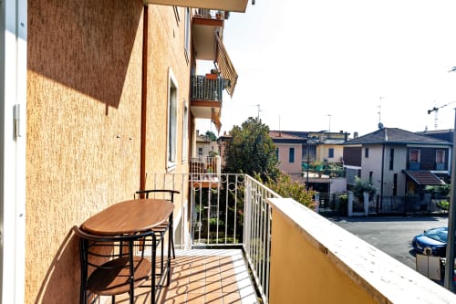 Balcone Solumnia Urban Nest 2 a Milano con tavolo, sedie e vista sulla città del quartiere residenziale