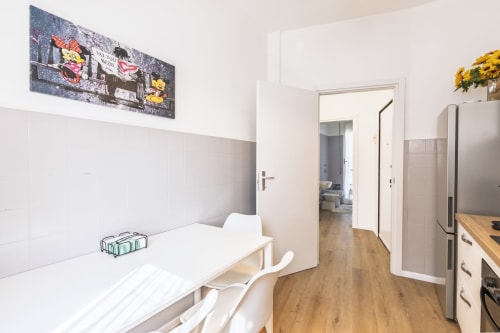 Cucina e zona pranzo moderna nell'appartamento Solumnia Urban Nest 2 a Milano, con mobiletto bianco e pavimenti in legno