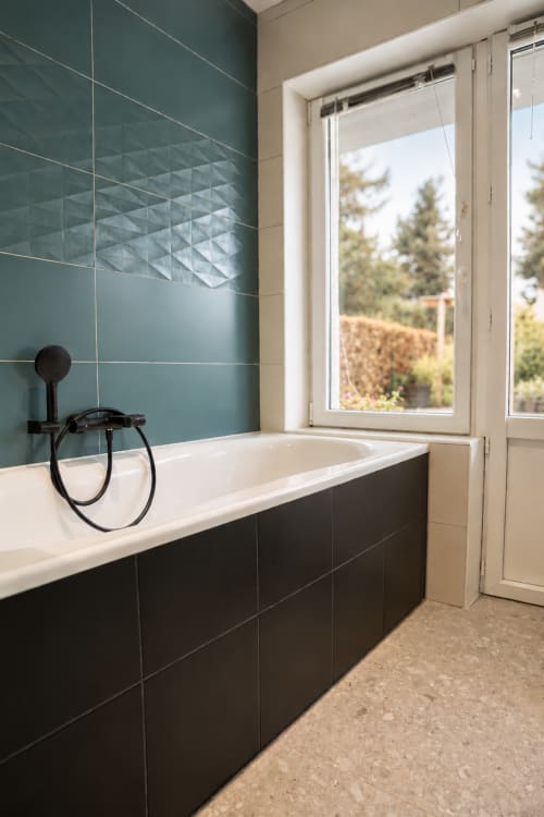 Salle de bain moderne chez Recevoir par Charline avec carrelage bleu canard, baignoire noire et fenêtre sur la forêt à Biganos