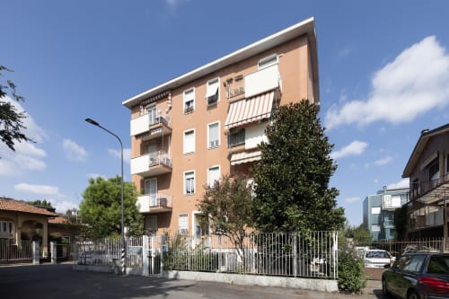 Edificio residenziale Solumnia Urban Nest a Milano con facciata color pesca, balconi, vista sulla città, design moderno