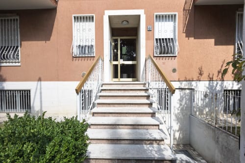 Ingresso Solumnia Urban Nest 2 a Milano con scale, balaustre bianche e facciata in terracotta