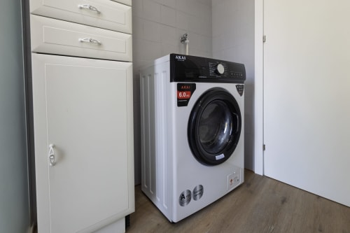 Lavatrice AKAI 6.0kg nella moderna lavanderia dell'appartamento Solumnia Urban Nest Milano
