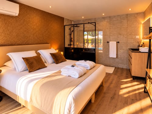 Chambre luxe à La Villa Monarque, Cap d'Agde avec vue sur la piscine, salle de bain moderne et lit king-size