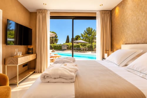 Luxueuse chambre à La Villa Monarque avec vue sur piscine, mobilier moderne, TV et accès direct à la terrasse à Cap d'Agde