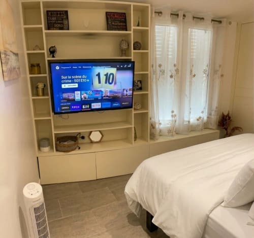 Chambre moderne au Paradis Des Logis avec TV murale, rangements intégrés et vue sur le jardin par portes-fenêtres