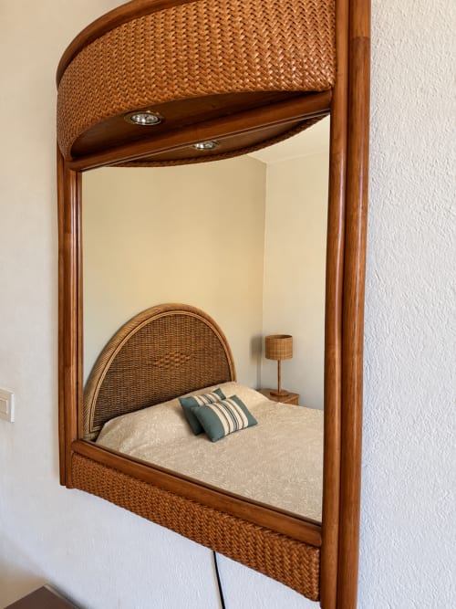 Lit-alcôve en rotin tressé avec tête de lit à l'Hôtel Thalassa à Cargèse, avec baldaquin en osier et coussin rayé