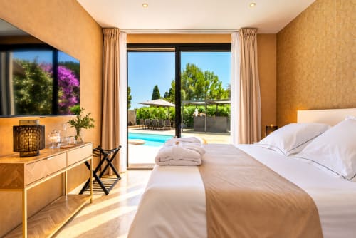 Chambre luxueuse à La Villa Monarque avec vue piscine, mobilier moderne et portes coulissantes donnant sur la terrasse, Cap
