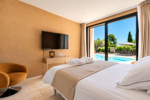 Chambre luxueuse à La Villa Monarque avec vue sur la piscine, mobilier moderne et accès à la terrasse à Cap d'Agde