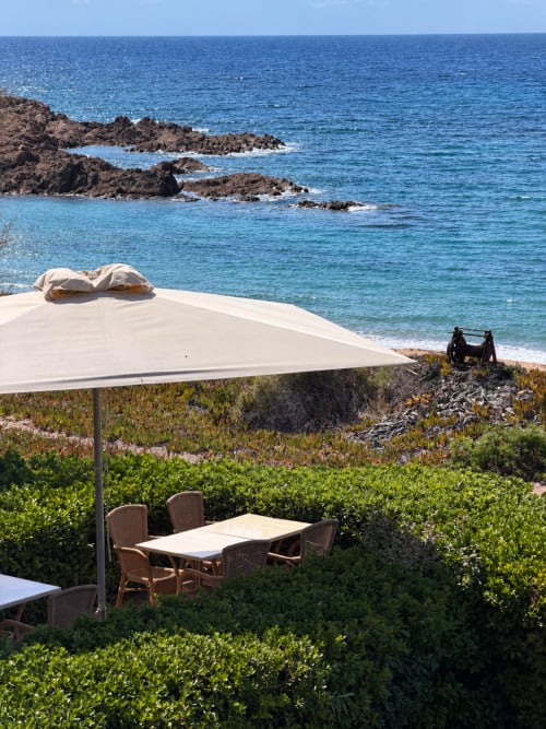 Terrasse de restauration en bord de mer à l'Hôtel Thalassa à Cargèse avec places ombragées surplombant la côte rocheuse