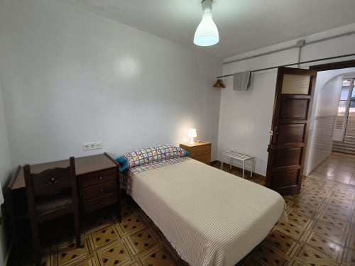 Habitación luminosa en Pensión Los Pinos Gijón con cama individual, muebles de madera y baño privado