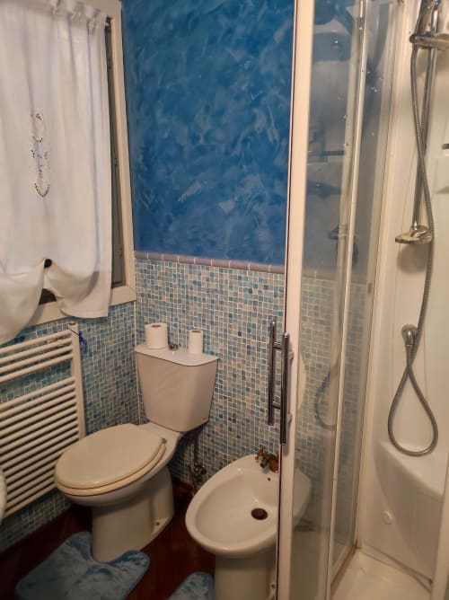 Bagno nella Suite Platone Prestige dell'hotel Gruppo Platone ad Alessandria con piastrelle a mosaico blu e doccia