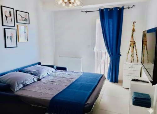 Chambre moderne à la Villa Benedettu des Villas d'A Storia, Porto-Vecchio, avec décoration bleue, lit queen-size et fenêtre