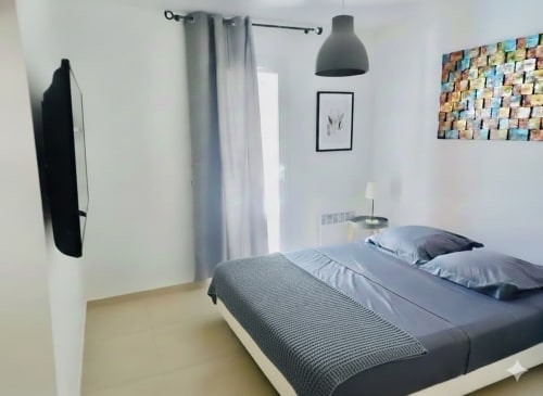 Chambre moderne à la Villa Benedettu des Villas d'A Storia, Porto-Vecchio : literie grise, suspension et applique murale
