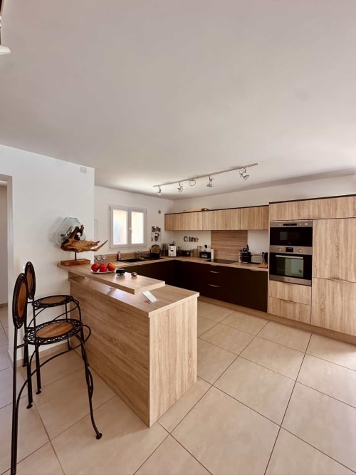 Cuisine contemporaine de la Villa Benedettu aux Villas d'A Storia, Porto-Vecchio, avec meubles en bois et îlot