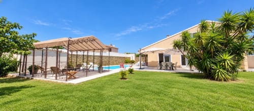 Villa Benedettu aux Villas d'A Storia à Porto-Vecchio dispose d'une terrasse au bord de la piscine, d'un coin lounge sous pergola, d'une pelouse bien entretenue et de