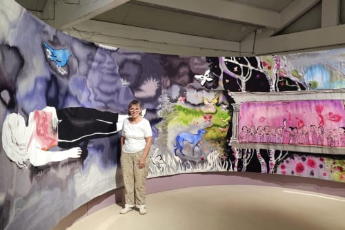 Woman standing in modern art gallery with colorful murals at Aux Prés Du Berry, Chavin, France