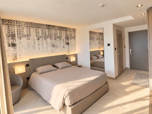 Modern studio bedroom at Attica Résidences in St-Sulpice with lake view, featuring contemporary bed and ambient lighting