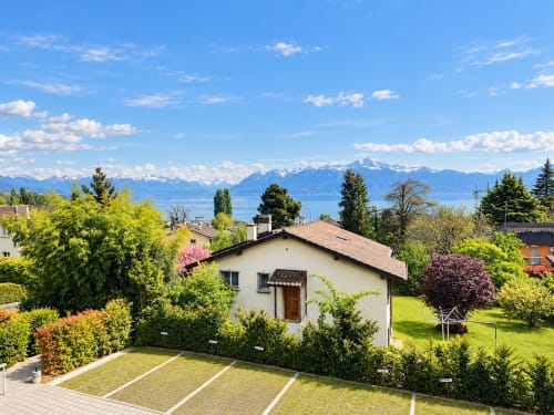Attica Résidences studio in St-Sulpice with lake and Alpine mountain views, green gardens, and modern architecture
