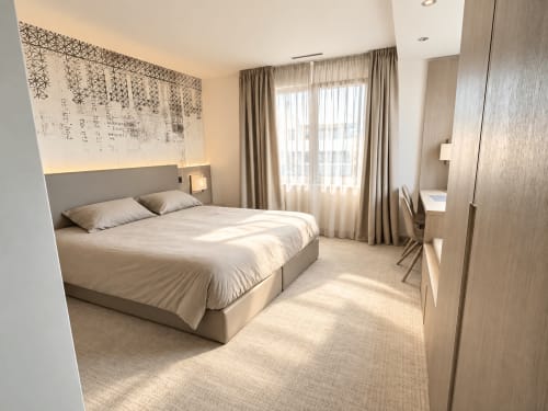 Modern studio bedroom at Attica Résidences in St-Sulpice with lake view, queen bed, and contemporary furnishings