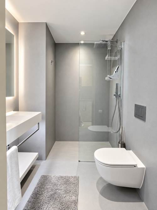 Modern bathroom at Attica Résidences St-Sulpice with glass shower, white toilet, floating vanity and heated towel rail