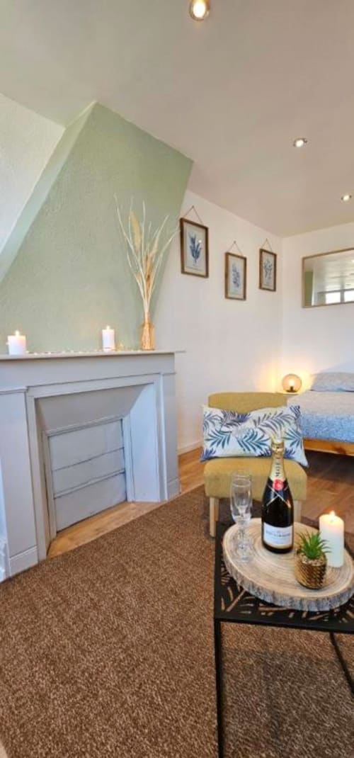 Chambre d'hôtel élégante à Saint-Valery-en-Caux avec cheminée, lit, bouteille de champagne et vue sur mer