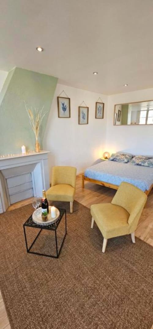 Chambre moderne aux Gites Saint Valery En Caux avec chaises jaunes, cheminée et vue sur mer depuis l'appartement La jungle