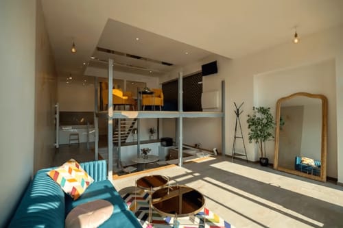Modern loft interior at Gites Saint Valery En Caux with mezzanine, turquoise sofa, and sea views