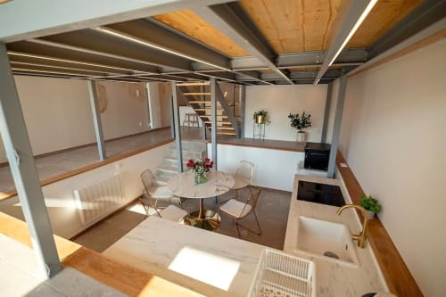 Modern loft interior at Gites Saint Valery En Caux with dining area, kitchen, and sea view from mezzanine level