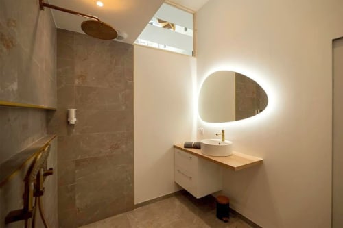 Modern bathroom in Loft Le Chic cottage at Gites Saint Valery En Caux with illuminated oval mirror, white vanity, and walk-in