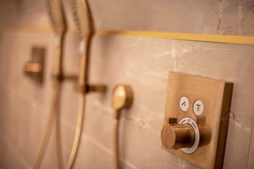 Luxury bathroom fixture with brass thermostatic mixer and control dials at Gites Saint Valery En Caux cottage