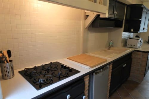 Cuisine moderne dans l'appartement La Suite aux Gîtes Saint Valéry En Caux avec cuisinière à gaz, carrelage blanc métro et noir