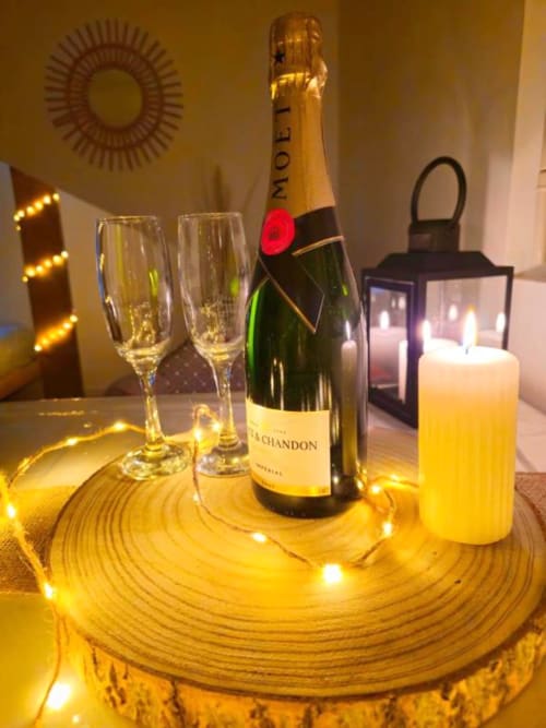 Elegant champagne table setting with Moët & Chandon bottle, two flutes, and candle at Gites Saint Valery En Caux
