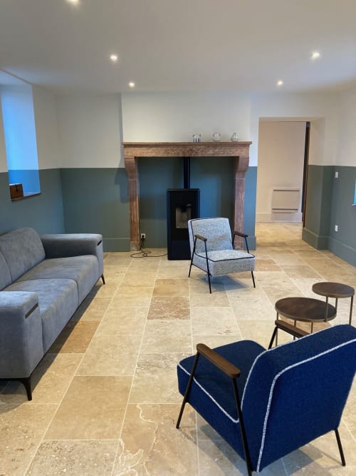 Salon de cottage moderne à LGA Molinet avec cheminée, fauteuils bleus et carrelage en pierre neutre