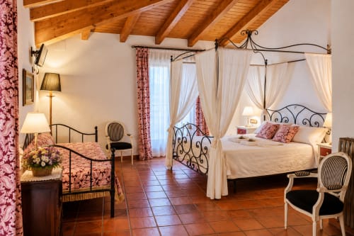 Elegante habitación boutique en El descanso del peregrino, Guadalupe con cama dosel, vigas de madera y vista a las montañas