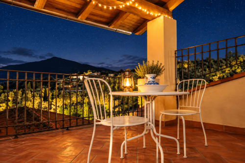 Terraza en la azotea iluminada por las estrellas en El descanso del peregrino en Guadalupe, Cáceres, con vistas a las montañas y asientos de bistró