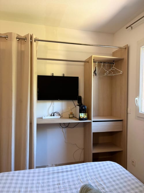 Studio 305 au Clos d'Aix, Aix-en-Provence : Bureau intégré en bois, TV, penderie et lit dans appartement moderne