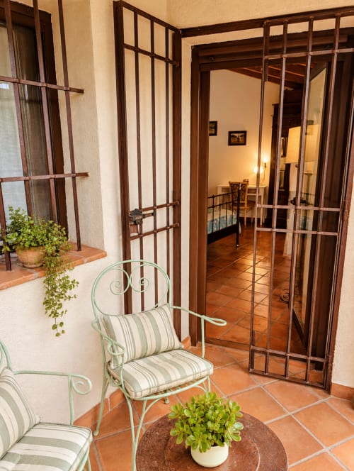 Patio de la suite boutique en El descanso del peregrino, Guadalupe con asientos rayados y vistas a la montaña