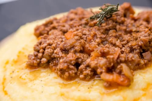 Cremosa polenta condita con ricco ragù di carne e rosmarino presso l'Antico Belvedere B&B, Italia