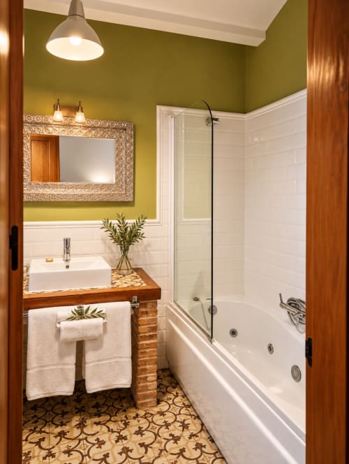 Baño boutique en El descanso del peregrino en Guadalupe con azulejos blancos tipo metro, paredes verde oliva y lavabo de madera