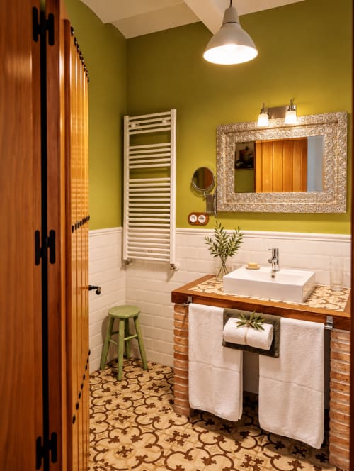 Baño boutique en El descanso del peregrino de Guadalupe con paredes amarillas, lavabo blanco, espejo decorativo y detalles con patrón