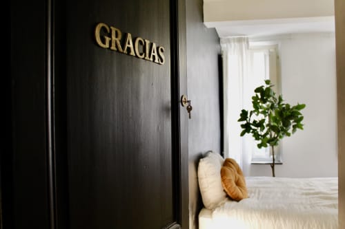 Entrée de la Suite Gracias à l'hôtel Mi Casa Es Su Casa à Carcassonne avec porte noire et linge blanc visible