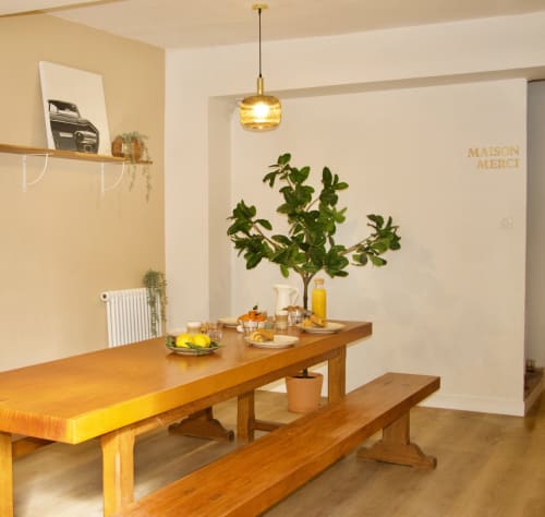Salle à manger lumineuse de la suite hôtel Mi Casa Es Su Casa avec table en bois, suspension, végétation fraîche et tons chauds neutres