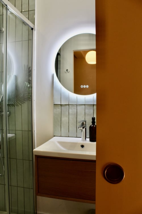 Salle de bain moderne de la Suite Arigato à Mi Casa Es Su Casa, Carcassonne, avec miroir illuminé rond et accent terracotta
